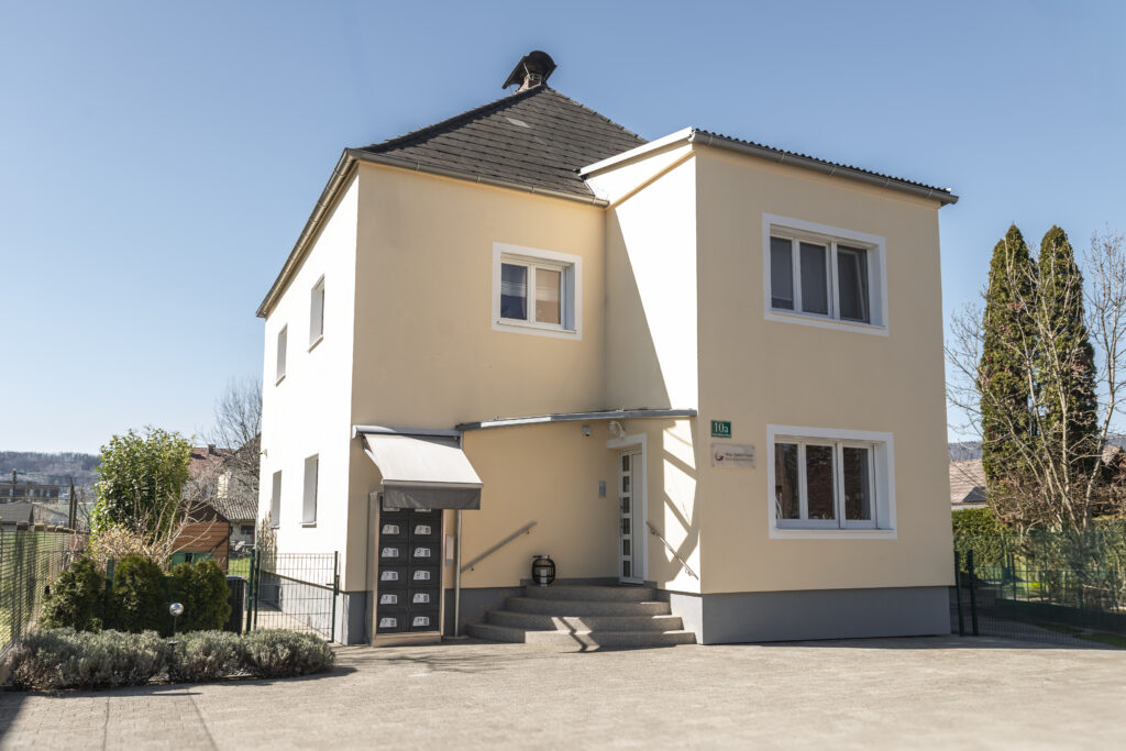 Mehrstöckiges Bürogebäude mit markanter gelber Fassade und großen Fensterfronten.